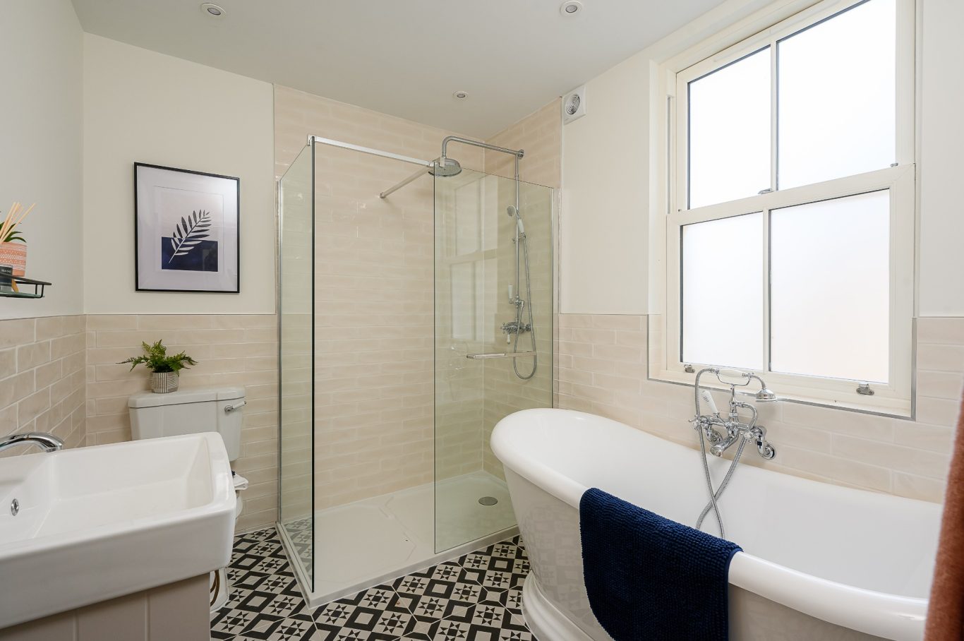 Modern bathroom featuring a shower, bathtub, and stylish tiles. Natural light from a window.